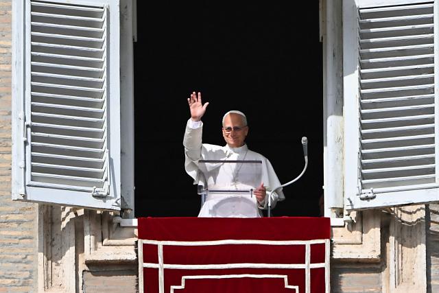 Pope Leo XIV waves to the crowd from the window of the apostolic palace overlooking St. Peter's square during the Angelus prayer in The Vatican on November 2, 2025. (Photo by Andreas SOLARO / AFP)
