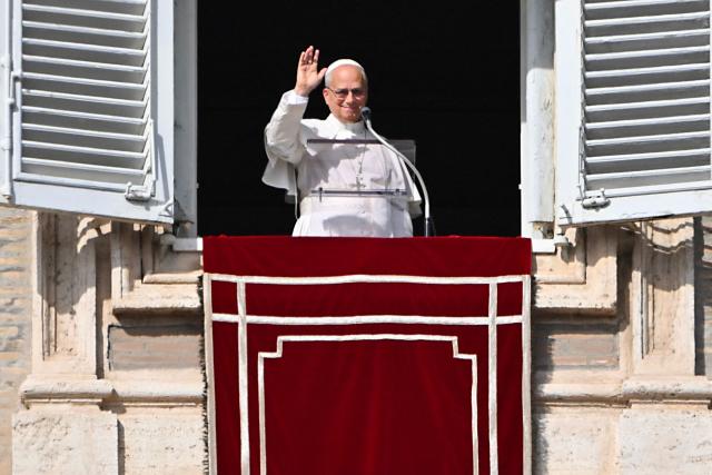Pope Leo XIV waves to the crowd from the window of the apostolic palace overlooking St. Peter's square during the Angelus prayer in The Vatican on November 2, 2025. (Photo by Andreas SOLARO / AFP)