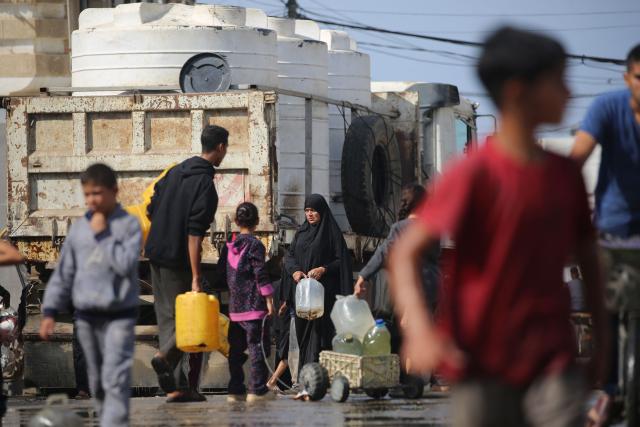 Palestinians fill containers with water at a collection point in a camp for displaced people in the Nuseirat refugee camp, located in the central Gaza Strip, on November 2, 2025. (Photo by EYAD BABA / AFP)