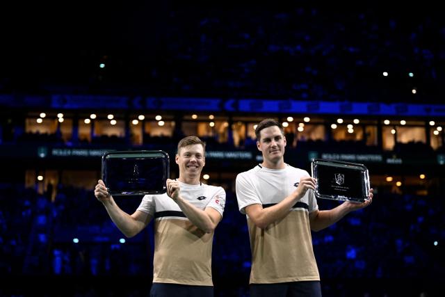 Finland's Harri Heliovaara (L) and Britain's Henry Patten celebrate with the trophy after winning against Britain's Julian Cash and Britain's Lloyd Glasspool at the end of the men's doubles final match on day seven of the Paris ATP Masters 1000 tennis tournament at the Paris La Défense Arena in Nanterre, on the outskirts of Paris, on November 2, 2025. (Photo by JULIEN DE ROSA / AFP)