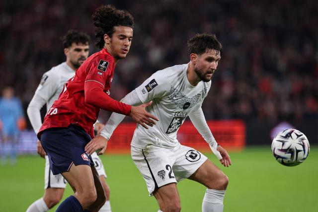 Lille's French midfielder #32 Ayyoub Bouaddi (L) fights for the ball with Angers' French defender #21 Jordan Lefort during the French L1 football match between LOSC Lille and Angers SCO at Stade Pierre-Mauroy in Villeneuve-d'Ascq, near Lille on November 2, 2025. (Photo by Anne-Christine POUJOULAT / AFP)