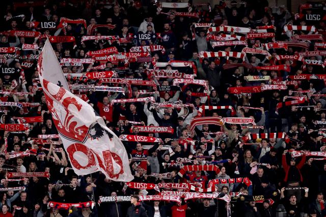 Lille's supporters hold banners as they cheer during the French L1 football match between LOSC Lille and Angers SCO at Stade Pierre-Mauroy in Villeneuve-d'Ascq, near Lille on November 2, 2025. (Photo by Anne-Christine POUJOULAT / AFP)