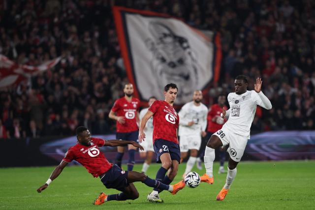 Lille's Congolese defender #18 Chancel Mbemba (L) and Lille's Algerian defender #23 Aissa Mandi (C) fights for the ball with Angers' French forward #36 Lanroy Machine (R) during the French L1 football match between LOSC Lille and Angers SCO at Stade Pierre-Mauroy in Villeneuve-d'Ascq, near Lille on November 2, 2025. (Photo by Anne-Christine POUJOULAT / AFP)
