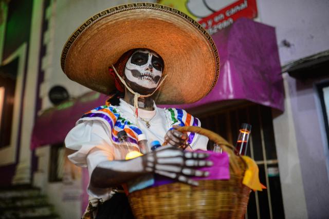 A woman dressed as a Catrina poses in the street during the Day of the Dead celebration in Naolinco de Victoria, Veracruz state, Mexico on November 2, 2025. (Photo by Antonio Martinez / AFP)