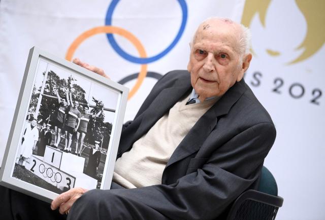 (FILES) French cyclist, and Olympic champion in the team pursuit during the 1948 Summer Olympics in London, Charles Coste poses with a photograph prior to receive the Legion d’honneur at the headquarters of the Paris 2024 Organising Committee for the Olympic and Paralympic Games, in Saint-Denis, outside Paris, on April 13, 2022. Cycling champions Charles Coste has died on October 30, 2025, at the age of 101, announced France's Minister of Sports, Marina Ferrari, on twitter on November 2, 2025. (Photo by FRANCK FIFE / AFP)