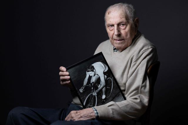 (FILES) Olympic champion in Men's Team Pursuit in track cycling at the 1948 London Games, Charles Coste, poses with a photo of himself when he was competing during a photo session at home in Bois-Colombes, northwestern of Paris, on January 30, 2024. Cycling champions Charles Coste has died on October 30, 2025, at the age of 101, announced France's Minister of Sports, Marina Ferrari, on twitter on November 2, 2025. (Photo by JOEL SAGET / AFP)