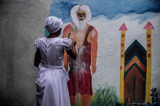 A woman attend Fet Gede, the traditional Haitian Day of the Dead celebration at the Port-au-Prince cemetery, in Haiti, on November 2, 2025. Fet Gede is the annual celebration when practitioners of vodou parade and believe to be possessed by the spirits of the dead. (Photo by Clarens SIFFROY / AFP)