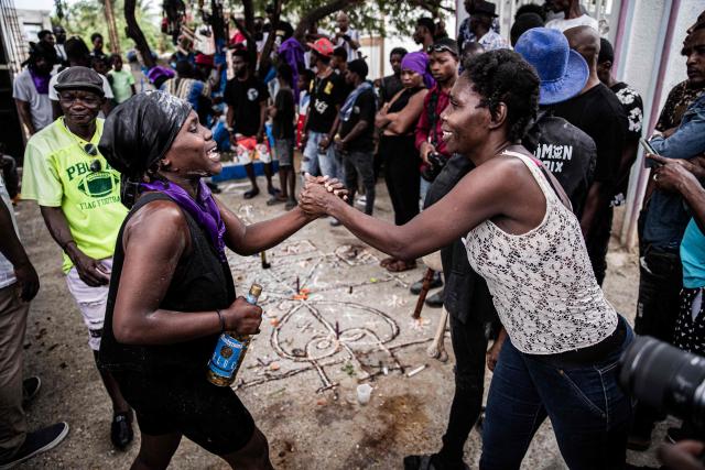 People attend Fet Gede, the traditional Haitian Day of the Dead celebration at the Port-au-Prince cemetery, in Haiti, on November 2, 2025. Fet Gede is the annual celebration when practitioners of voodoo parade and believe to be possessed by the spirits of the dead. (Photo by Clarens SIFFROY / AFP)