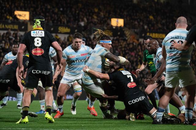 Racing 92's Fijian lock Nathan Hughes (C) is tackled during the French Top14 rugby union match between Stade Rochelais (La Rochelle) and Racing 92 at The Marcel-Deflandre Stadium in La Rochelle, western France on November 2, 2025. (Photo by XAVIER LEOTY / AFP)