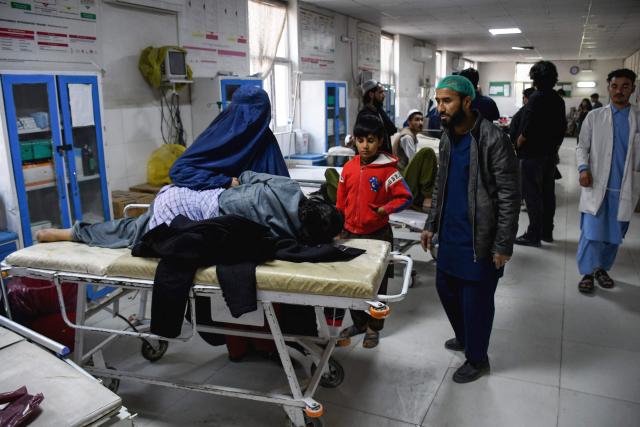 An Afghan burqa-clad woman sits beside an earthquake victim receiving treatment at a hospital in Mazar-i-Sharif on November 3, 2025. A 6.3-magnitude strong earthquake that struck overnight killed at least nine people in northern Afghanistan, authorities said on November 3, just months after another deadly tremor left the country reeling. (Photo by Atif Aryan / AFP)