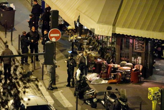(FILES) A victim lies on the ground covered by a white sheet outside the cafe "La Bonne Biere" in Paris, on November 13, 2015 following an attack. November 15, 2025 will mark the tenth anniversary of the November 13 attacks, a series of gun attacks that occurred across Paris and outside the national stadium (Stade de France) in Saint-Denis, North of Paris, on November 13, 2015. (Photo by Kenzo TRIBOUILLARD / AFP)