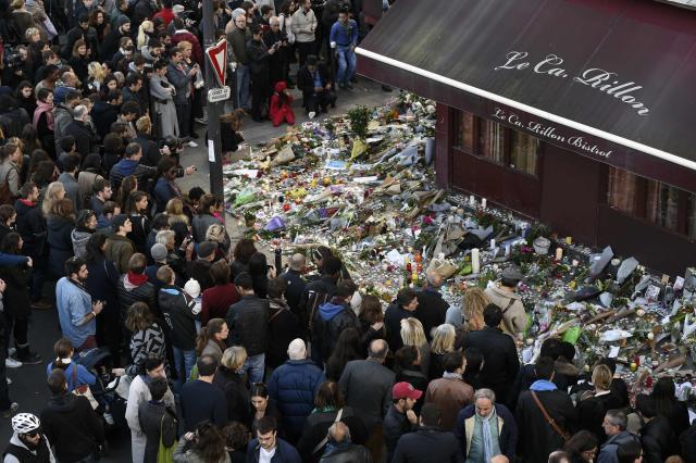 (FILES) People gather at a makeshift memorial in front of "Le carillon" restaurant in the 10th district of Paris on November 15, 2015, following a series of coordinated terrorists attacks on November 13. November 15, 2025 will mark the tenth anniversary of the November 13 attacks, a series of gun attacks that occurred across Paris and outside the national stadium (Stade de France) in Saint-Denis, North of Paris, on November 13, 2015. (Photo by Alain JOCARD / AFP)