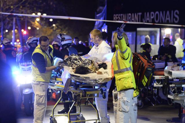 (FILES) Rescuers evacuate an injured person near the Bataclan concert hall in central Paris, early on November 14, 2015. November 15, 2025 will mark the tenth anniversary of the November 13 attacks, a series of gun attacks that occurred across Paris and outside the national stadium (Stade de France) in Saint-Denis, North of Paris, on November 13, 2015. (Photo by Miguel MEDINA / AFP)