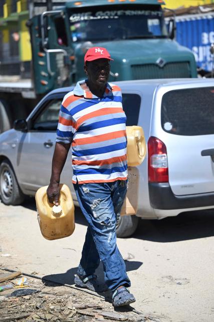 A man walks along the main road in search of gasoline in Westmoreland, Jamaica, following the passage of Hurricane Melissa, on November 2, 2025. Planes and helicopters carrying humanitarian aid headed to Jamaica on October 31, three days after Melissa slammed into the island nation and killed at least 19 people.
Information Minister Dana Morris Dixon told a briefing that authorities had "quite credible" reports of possibly five additional deaths but had not yet been able to confirm. (Photo by Ricardo Makyn / AFP)