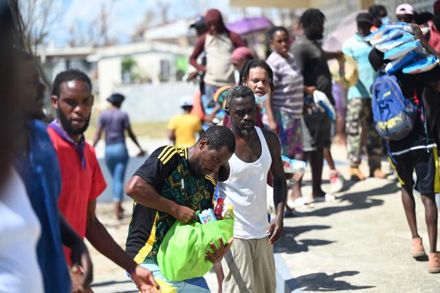 Residents help move food supplies at a community center before distribution to the Whitehouse community in Westmoreland, one of the areas most severely affected by the passage of Hurricane Melissa, on November 2, 2025. Planes and helicopters carrying humanitarian aid headed to Jamaica on October 31, three days after Melissa slammed into the island nation and killed at least 19 people.
Information Minister Dana Morris Dixon told a briefing that authorities had "quite credible" reports of possibly five additional deaths but had not yet been able to confirm. (Photo by Ricardo MAKYN / AFP)