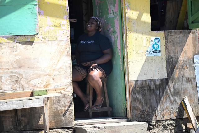 A bar worker smiles while sitting at the entrance to her establishment in Westmoreland, Jamaica, following the passage of Hurricane Melissa, on November 2, 2025. Planes and helicopters carrying humanitarian aid headed to Jamaica on October 31, three days after Melissa slammed into the island nation and killed at least 19 people.
Information Minister Dana Morris Dixon told a briefing that authorities had "quite credible" reports of possibly five additional deaths but had not yet been able to confirm. (Photo by Ricardo Makyn / AFP)