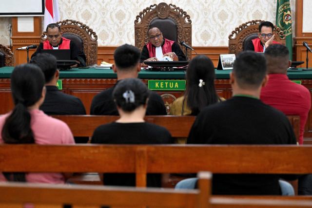 Witnesses sit in front the judge during the trial of Australian suspect Darcy Francesco Jenson at a courtroom in Denpasar on Indonesia's resort island of Bali on November 3, 2025. The trial of three Australians accused of plotting the murder of a compatriot at a villa in Bali began on October 30, 2025, with all facing the death penalty. (Photo by SONNY TUMBELAKA / AFP)