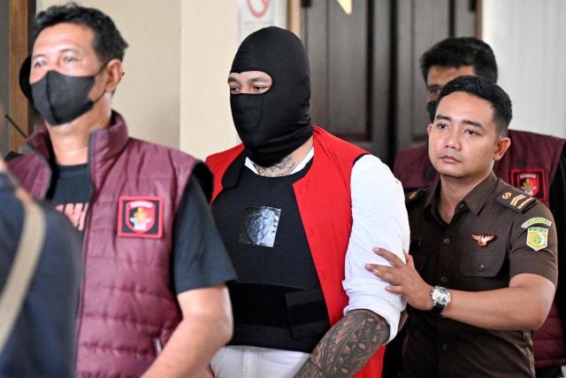 CORRECTION / Australian suspect Paea-I-Middlemore Tupou (L) is escorted by the police out of a courtroom after attending a hearing as part of attends his trial in Denpasar on Indonesia's resort island of Bali on November 3, 2025. The trial of three Australians accused of plotting the murder of a compatriot at a villa in Bali began on October 30, 2025, with all facing the death penalty. (Photo by SONNY TUMBELAKA / AFP) / The erroneous mention[s] appearing in the metadata of this photo by SONNY TUMBELAKA has been modified in AFP systems in the following manner: [Paea-I-Middlemore Tupou] instead of [Tupou Pasa Midolmore]. Please immediately remove the erroneous mention[s] from all your online services and delete it (them) from your servers. If you have been authorized by AFP to distribute it (them) to third parties, please ensure that the same actions are carried out by them. Failure to promptly comply with these instructions will entail liability on your part for any continued or post notification usage. Therefore we thank you very much for all your attention and prompt action. We are sorry for the inconvenience this notification may cause and remain at your disposal for any further information you may require.