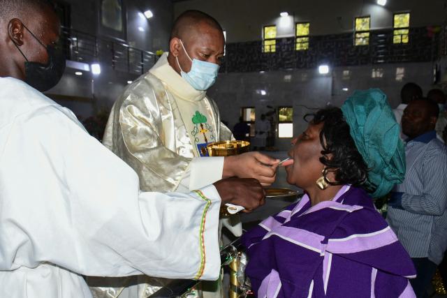 Christian devotees take communion during a Christmas mass at St. Patrick's Church in Maiduguri on December 25, 2021. US President Donald Trump on Sunday repeated his threat of a military operation in Nigeria over killings of Christians, after the Nigerian presidency suggested a meeting to resolve the issue.
Asked by an AFP reporter aboard Air Force One if he was considering US troops on the ground in Nigeria or air strikes, Trump replied: "Could be, I mean, a lot of things -- I envisage a lot of things." (Photo by Audu MARTE / AFP)