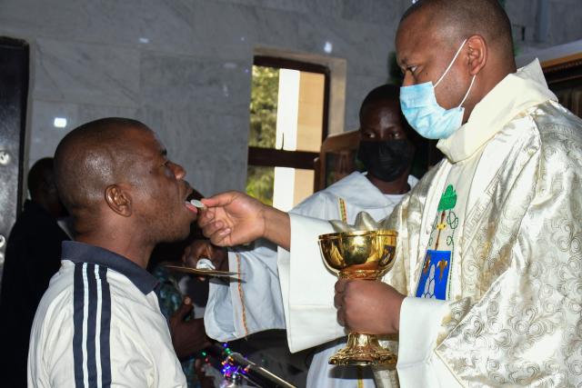 Christian devotees take communion during a Christmas mass at St. Patrick's Church in Maiduguri on December 25, 2021. US President Donald Trump on Sunday repeated his threat of a military operation in Nigeria over killings of Christians, after the Nigerian presidency suggested a meeting to resolve the issue.
Asked by an AFP reporter aboard Air Force One if he was considering US troops on the ground in Nigeria or air strikes, Trump replied: "Could be, I mean, a lot of things -- I envisage a lot of things." (Photo by Audu MARTE / AFP)