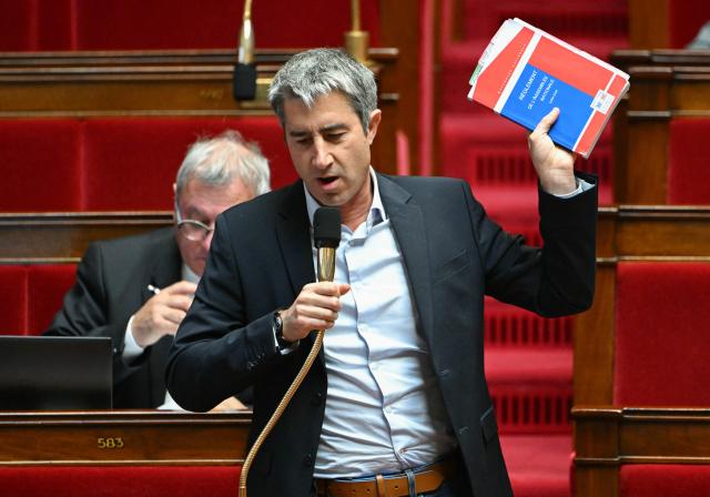 Ecologiste et Social's MP Francois Ruffin holds a regulation book of the National Assembly as he speaks during a parliamentary debate focused on the 2026 budget at The National Assembly, France's lower house parliament, in Paris on November 3, 2025. (Photo by Bertrand GUAY / AFP)