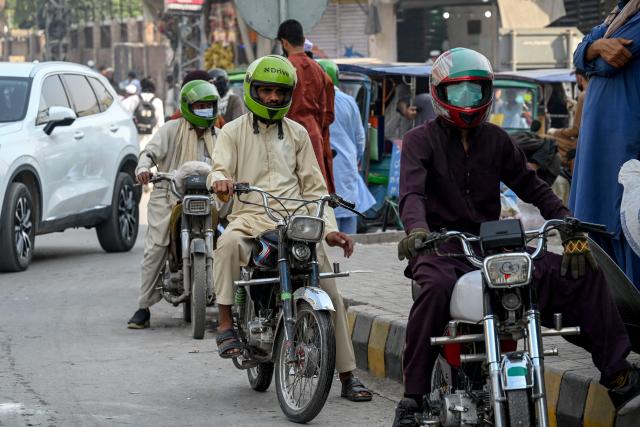 Motorbike taxi drivers offering ride-hailing services wait for passengers in Peshawar on November 3, 2025. (Photo by Abdul MAJEED / AFP)