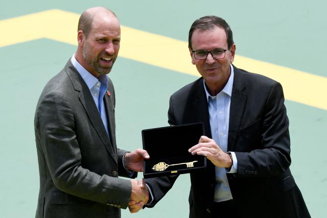 Britain's Prince William, Prince of Wales (L), receives the keys to the city from Rio de Janeiro's mayor Eduardo Paes during the “Welcome to Brazil” event at Sugarloaf Mountain in Rio de Janeiro on November 3, 2025. Prince William visits Brazil for the Earthshot Prize awards and will later attend the UN COP30 climate summit on behalf of King Charles. (Photo by Daniel RAMALHO / AFP)