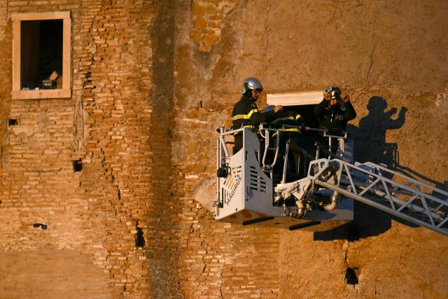 Firefighters work on the site after a part of medieval tower "Torre dei Conti" collapses near the Roman Forum in the historic center of Rome on November 3, 2025. Three workers inside were evacuated, with one taken to hospital in critical condition, a spokesman for firefighters told AFP. But one worker remained inside, according to an official from the mayor's office. (Photo by Filippo MONTEFORTE / AFP)