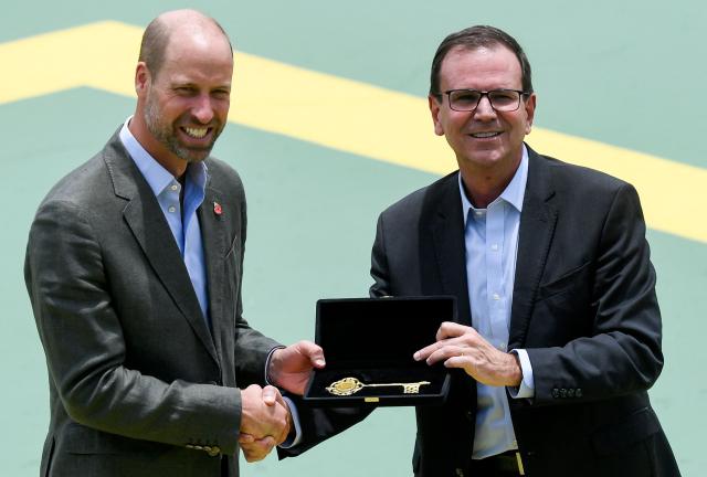 Britain's Prince William, Prince of Wales (L), receives the keys to the city from Rio de Janeiro's mayor Eduardo Paes during the “Welcome to Brazil” event at Sugarloaf Mountain in Rio de Janeiro on November 3, 2025. Prince William visits Brazil for the Earthshot Prize awards and will later attend the UN COP30 climate summit on behalf of King Charles. (Photo by Daniel RAMALHO / AFP)