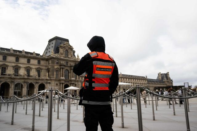 A private security guard patrols in the courtyard of the Louvre museum, in Paris on November 3, 2025. (Photo by Julie SEBADELHA / AFP)