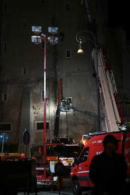 Firefighters enter the medieval tower "Torre dei Conti" where a worker is still trapped after the tower partially collapse, near the Roman Forum in the historic center of Rome on November 3, 2025. Three workers inside were evacuated, with one taken to hospital in critical condition, a spokesman for firefighters told AFP. But one worker remained inside, according to an official from the mayor's office. (Photo by Filippo MONTEFORTE / AFP)