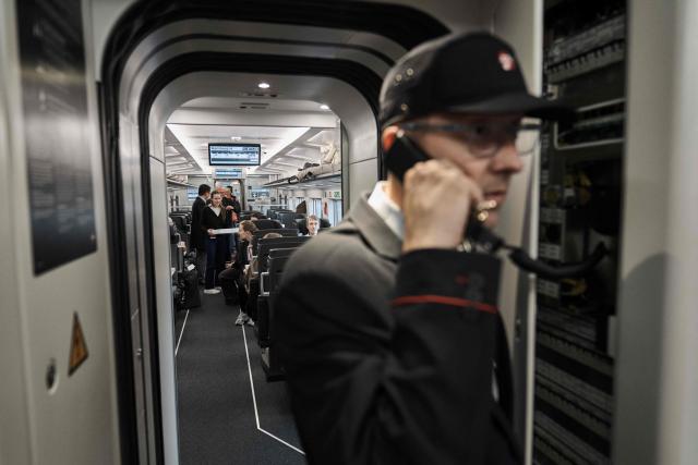 A train conductor and passengers are seen inside a new EuroCity train carriage of Denmark's national rail operator DSB prior to its first trip departing from Copenhagen on November 3, 2025. DSB's new EuroCity carriages will run on the route between Copenhagen Central Station and Hamburg Central Station. (Photo by Thomas Traasdahl / Ritzau Scanpix / AFP) / Denmark OUT