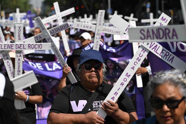 Members of the feminist collective "Voces de la Ausencia" carry crosses during a march called "Day of the Women Dead" in memory of women killed in gender-based violence and femicides, and to demand justice and reparations for indirect victims, in Mexico City on November 3, 2025. (Photo by Yuri CORTEZ / AFP)
