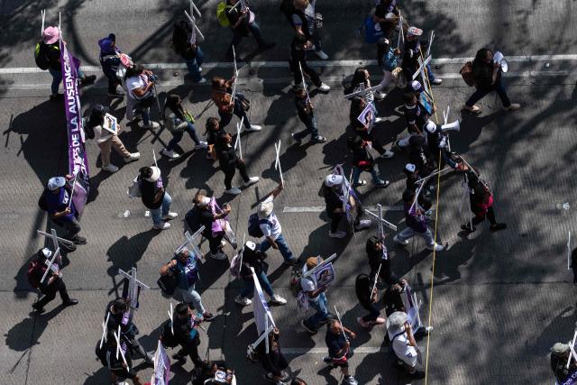 Members of the feminist collective "Voces de la Ausencia" carry crosses during a march called "Day of the Women Dead" in memory of women killed in gender-based violence and femicides, and to demand justice and reparations for indirect victims, in Mexico City on November 3, 2025. (Photo by Yuri CORTEZ / AFP)