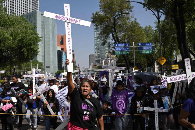 Members of the feminist collective "Voces de la Ausencia" carry crosses during a march called "Day of the Women Dead" in memory of women killed in gender-based violence and femicides, and to demand justice and reparations for indirect victims, in Mexico City on November 3, 2025. (Photo by Yuri CORTEZ / AFP)