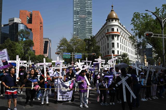 Members of the feminist collective "Voces de la Ausencia" carry crosses during a march called "Day of the Women Dead" in memory of women killed in gender-based violence and femicides, and to demand justice and reparations for indirect victims, in Mexico City on November 3, 2025. (Photo by Yuri CORTEZ / AFP)