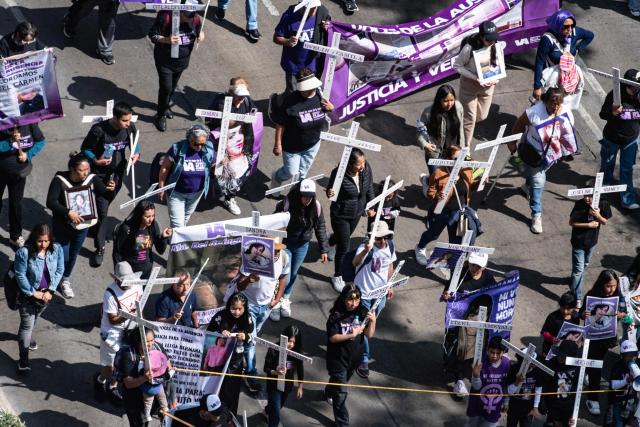Members of the feminist collective "Voces de la Ausencia" carry crosses during a march called "Day of the Women Dead" in memory of women killed in gender-based violence and femicides, and to demand justice and reparations for indirect victims, in Mexico City on November 3, 2025. (Photo by Yuri CORTEZ / AFP)