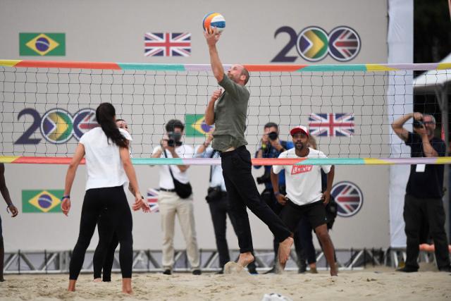 Britain's Prince William (C), Prince of Wales, plays volleyball at a meeting with first responder lifeguards at Copacabana Beach in Rio de Janeiro, Brazil on November 3, 2025. Prince William visits Brazil to host the Earthshot Prize awards and will later attend the UN COP30 climate summit on behalf of King Charles. (Photo by Daniel RAMALHO / AFP)
