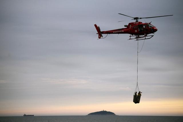 First responder lifeguards perform an exercise for Britain's Prince William, Prince of Wales, at Copacabana Beach in Rio de Janeiro, Brazil, on November 3, 2025. Prince William visits Brazil to host the Earthshot Prize awards and will later attend the UN COP30 climate summit on behalf of King Charles. (Photo by Daniel RAMALHO / AFP)