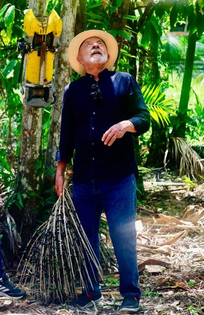 Brazil's President Luiz Inacio Lula da Silva observes how the robot that harvests acai berries works during a visit to Ilha Grande Agroextractive Settlement near Belem, Para State, Brazil, on November 3, 2025. Brazil recorded its biggest annual fall in greenhouse gas emissions last year since 2009, according to statistics released Monday, providing a boost for left-wing President Luiz Inacio Lula da Silva as he prepares to host UN climate talks. (Photo by Tarso Sarraf / AFP)