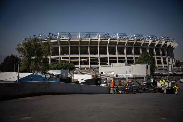 Workers clear an area outside the Azteca Stadium in Mexico City on October 28, 2025, where food stalls were recently removed. While millions celebrate Mexico hosting the FIFA World Cup for a third time, entire families of street vendors watch with concern as the football festivities threaten their long-standing source of income. (Photo by CARL DE SOUZA / AFP)