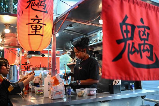 A cook from the Japanese food stall "Chido" prepares ramen, a traditional Japanese noodle dish, in Mexico City on October 29, 2025. While millions celebrate Mexico hosting the FIFA World Cup for a third time, entire families of street vendors watch with concern as the football festivities threaten their long-standing source of income. (Photo by Yuri CORTEZ / AFP)