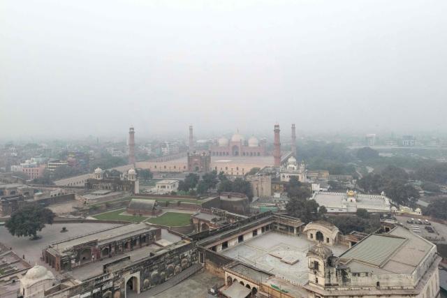 An aerial view shows the Badshahi Mosque engulfed in dense smog in Lahore on November 4, 2025.  (Photo by Syed Murtaza Ali / AFP)
