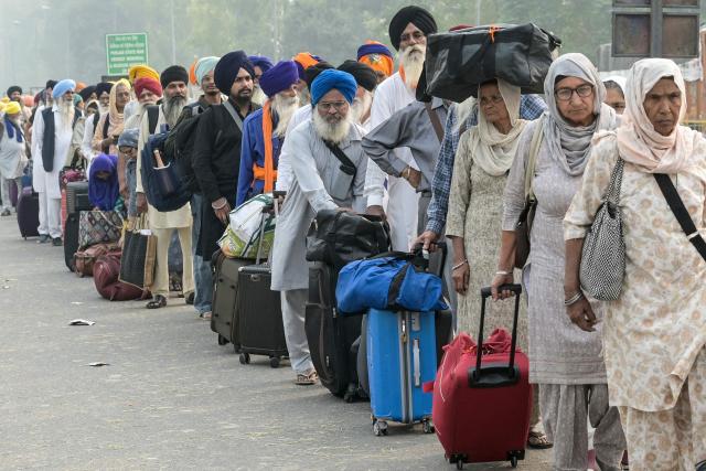 Indian Sikh pilgrims queue at the India-Pakistan Wagah border in Wagah on November 4, 2025, for their visit to Pakistan to pay their respects on the eve of celebrations marking the birth anniversary of Guru Nanak, founder of Sikhism. Indian Sikh pilgrims have been issued visas for neighbouring Pakistan, the first major allowance after travel between the arch-rival nations was frozen during conflict in May. (Photo by Narinder NANU / AFP)