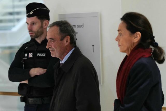 Former Director General of Lafarge Bruno Lafont (C) and French lawyer Jacqueline Laffont arrive on the opening day of the trial of the French cement group Lafarge and eight individuals, including former executives, accused of financing terrorism in Syria, at the Paris courthouse, in Paris, on November 4, 2025. Cement group Lafarge goes on trial in France on November 4, 2025, accused of paying the Islamic State group and other jihadists protection money to build its business in war-torn Syria. (Photo by Dimitar DILKOFF / AFP)