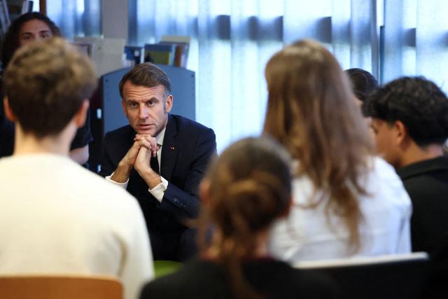 French President Emmanuel Macron attends a discussion with middle and high school students about the role of social media in our society, at La Fayette Middle School in Rochefort, on November 4, 2025. (Photo by Stephane Mahe / POOL / AFP)
