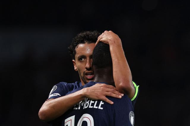 TOPSHOT - Paris Saint-Germain's Brazilian defender #05 Marquinhos (L) cheers Paris Saint-Germain's French forward #10 Ousmane Dembele who scored a goal which was later disallowed after a VAR review during the UEFA Champions League, league phase day 4, football match between Paris Saint-Germain (PSG) and FC Bayern Munich at the Parc des Princes in Paris, on November 4, 2025. (Photo by Anne-Christine POUJOULAT / AFP)