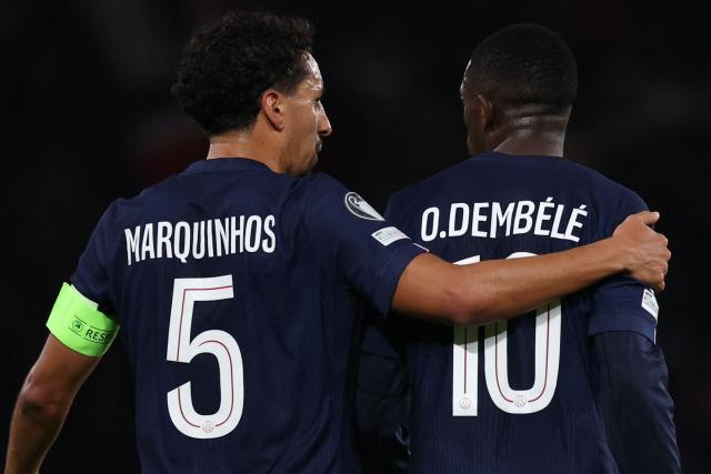 Paris Saint-Germain's Brazilian defender #05 Marquinhos (L) cheers Paris Saint-Germain's French forward #10 Ousmane Dembele who scored a goal which was later disallowed after a VAR review during the UEFA Champions League, league phase day 4, football match between Paris Saint-Germain (PSG) and FC Bayern Munich at the Parc des Princes in Paris, on November 4, 2025. (Photo by Anne-Christine POUJOULAT / AFP)