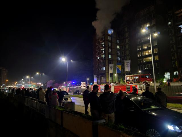 Bystanders watch the scene of a blaze after fire broke out in a nursing home, in the North-Eastern Bosnian city of Tuzla, late on November 4, 2025. (Photo by -STR / AFP)
