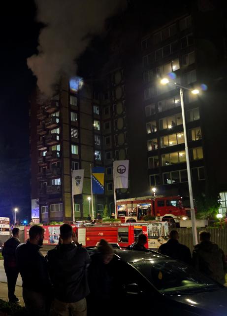 Bystanders watch the scene of a blaze after fire broke out in a nursing home, in the North-Eastern Bosnian city of Tuzla, late on November 4, 2025. (Photo by -STR / AFP)